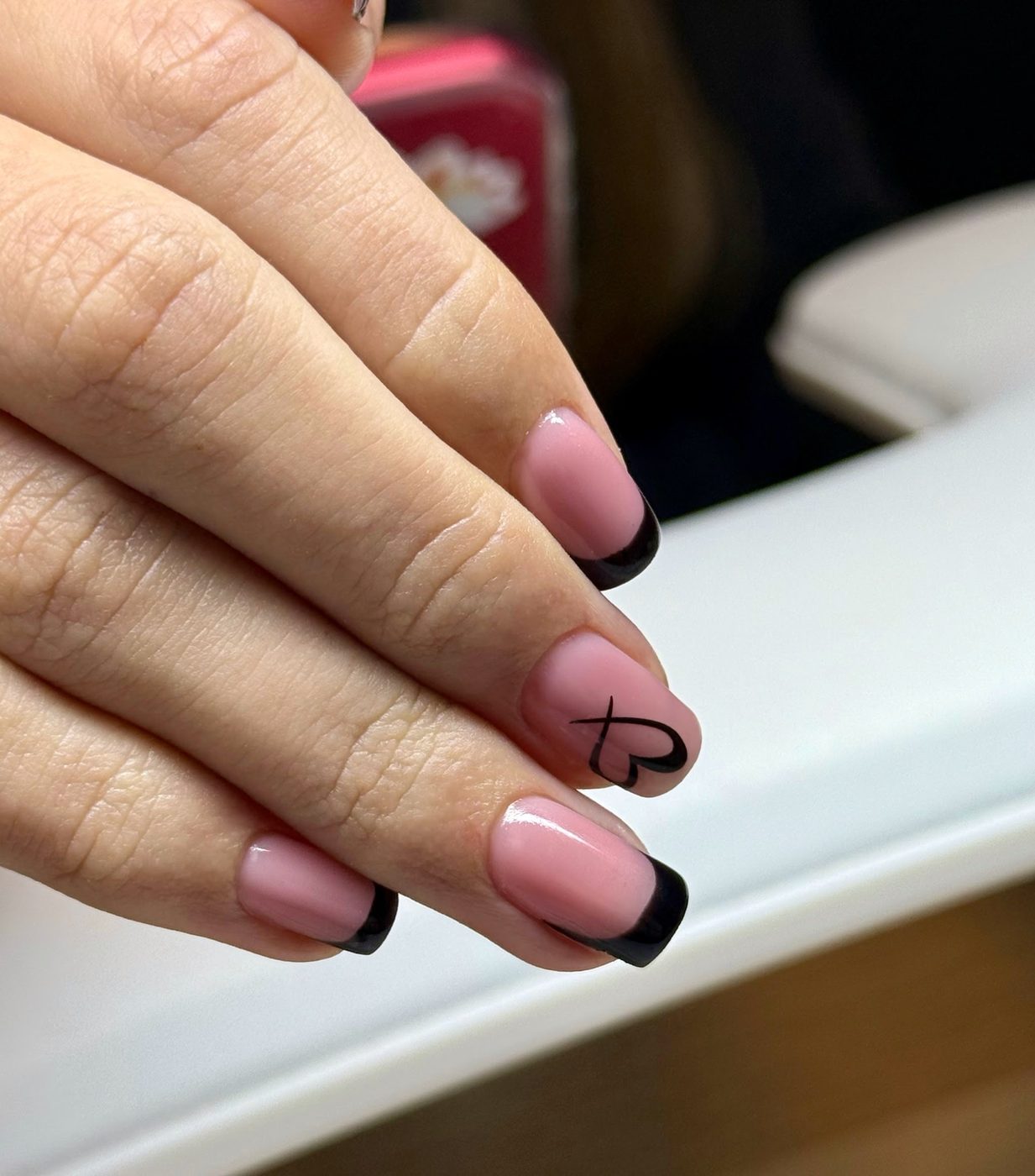 Roze nagels met zwarte french tips en een fijne lijntekening