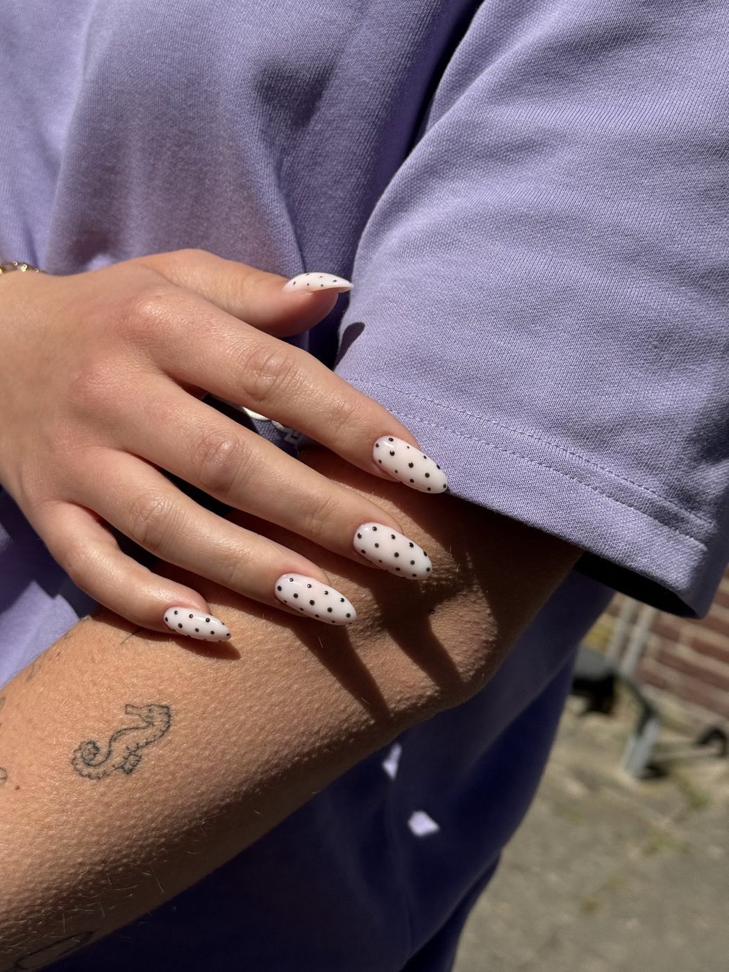 Witte amandelvormige nagels met zwarte stippen