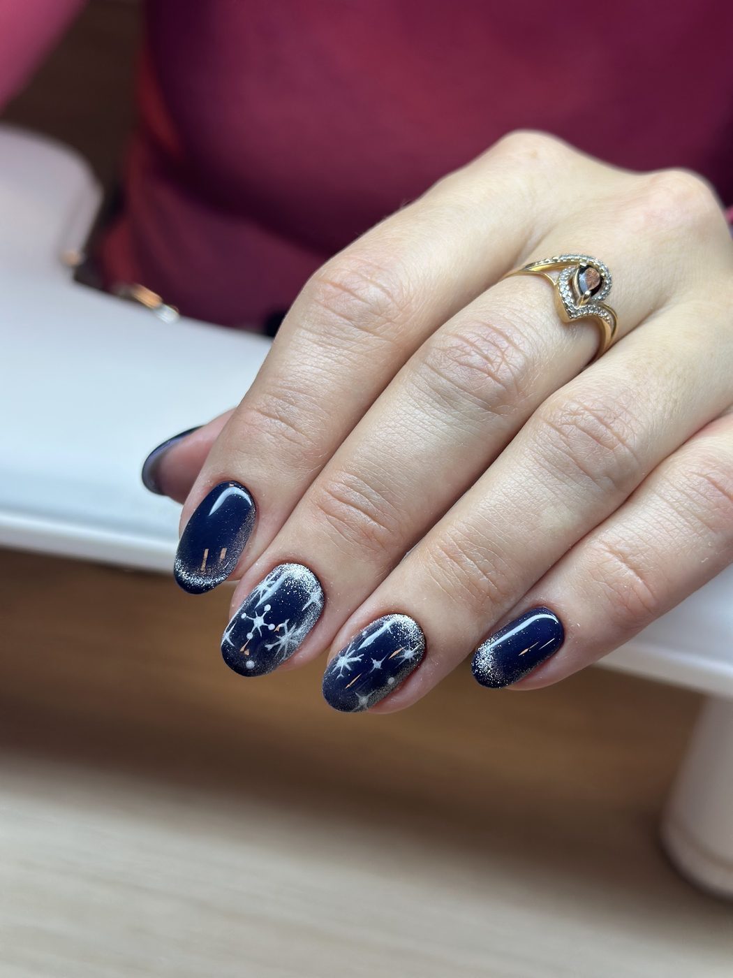 Donkerblauwe nagels met zilveren sterren en sneeuwvlokken